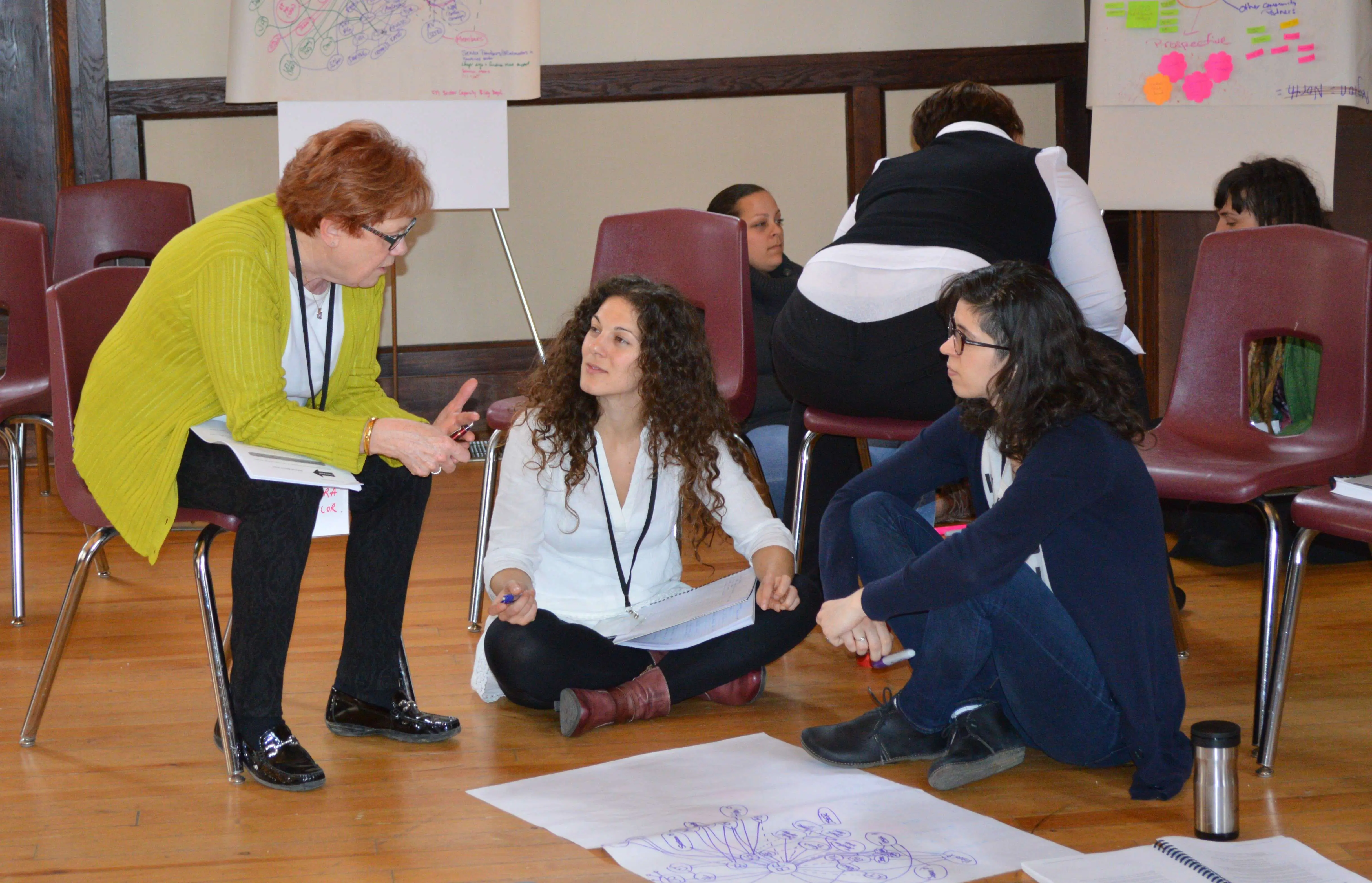 Three people discussing evaluation in a meeting room