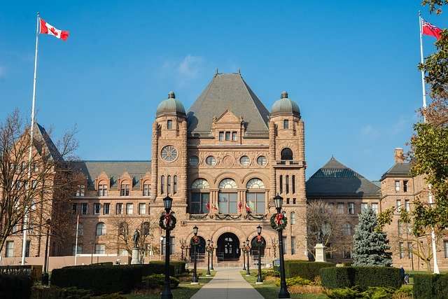 This is a photo of the Ontario government building. There are two flags outside. One flag is the Canadian flag and the second flag is the Ontario flag.